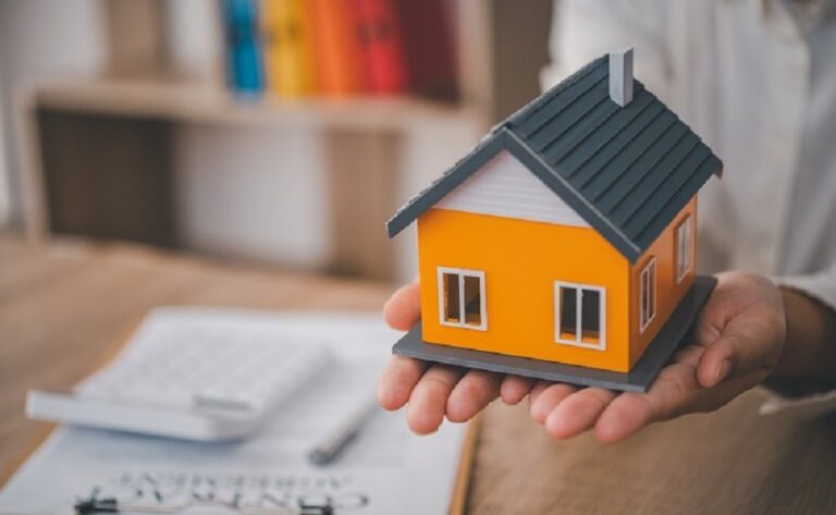 Close up view hand of property realtor giving house keys to new owner after signing contract. Real estate, mortgage and loan