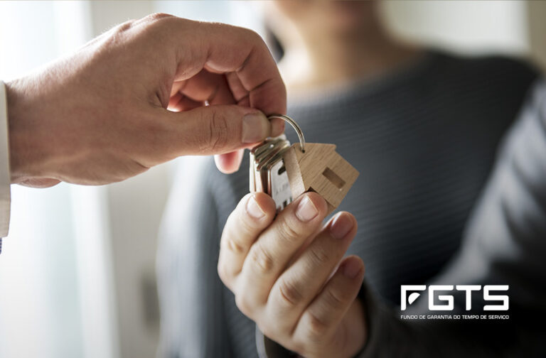 Close up view hand of property realtor giving house keys to new owner after signing contract. Real estate, mortgage and loan Imagem para ilustrar texto de blog sobre uso do FGTS na compra do primeiro imóvel